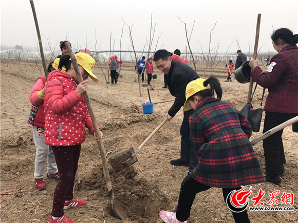 定陶区文明办副主任马景涛正在挖坑植树