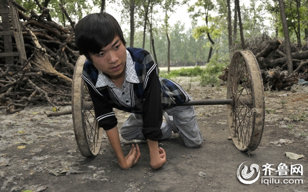 "坚强弟"苏进园在靠两个车轮在地上爬行 于鹏/摄影